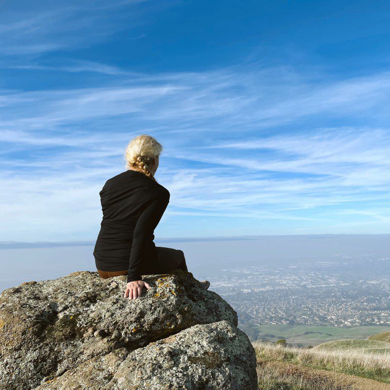 Carrie Green Zinn on a rock looking at the view from Mission Peak Trail