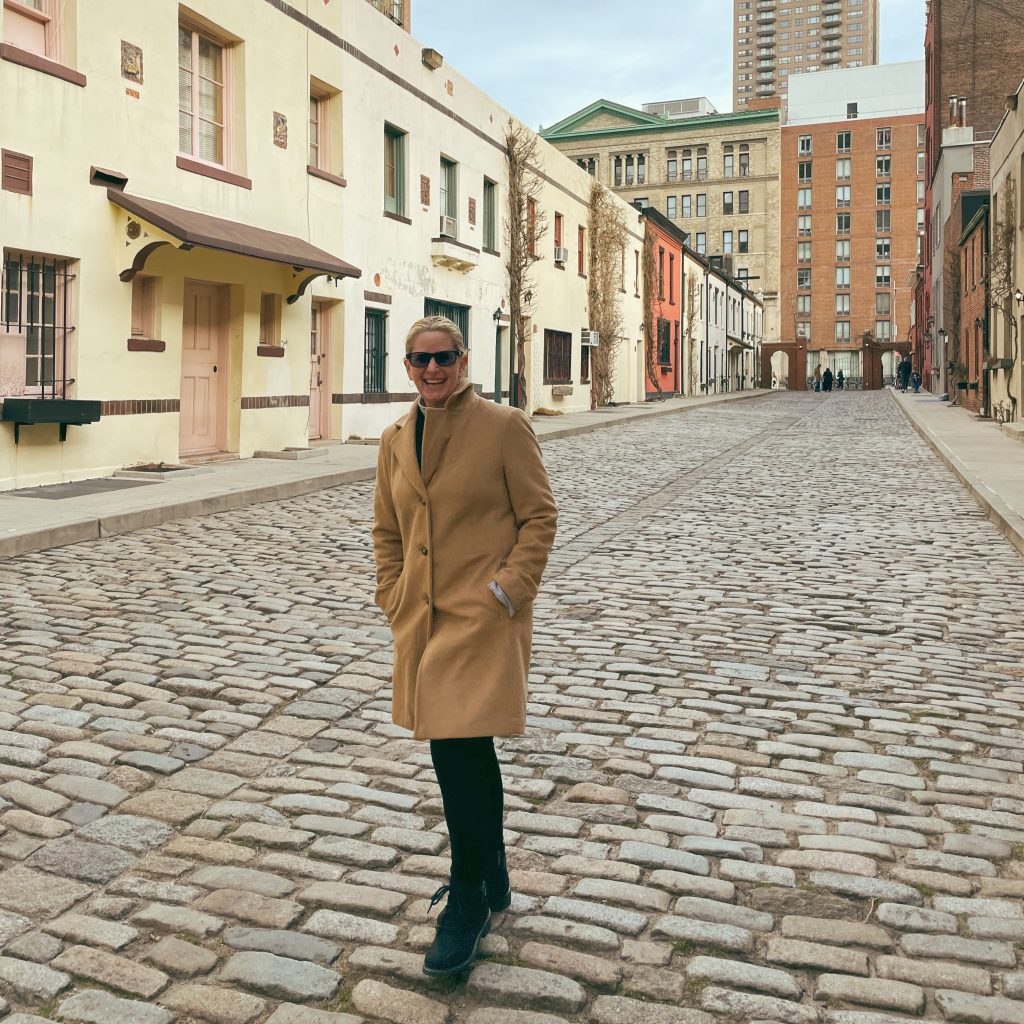 Carrie Green Zinn on a cobblestone street in Greenwich Village, New York City