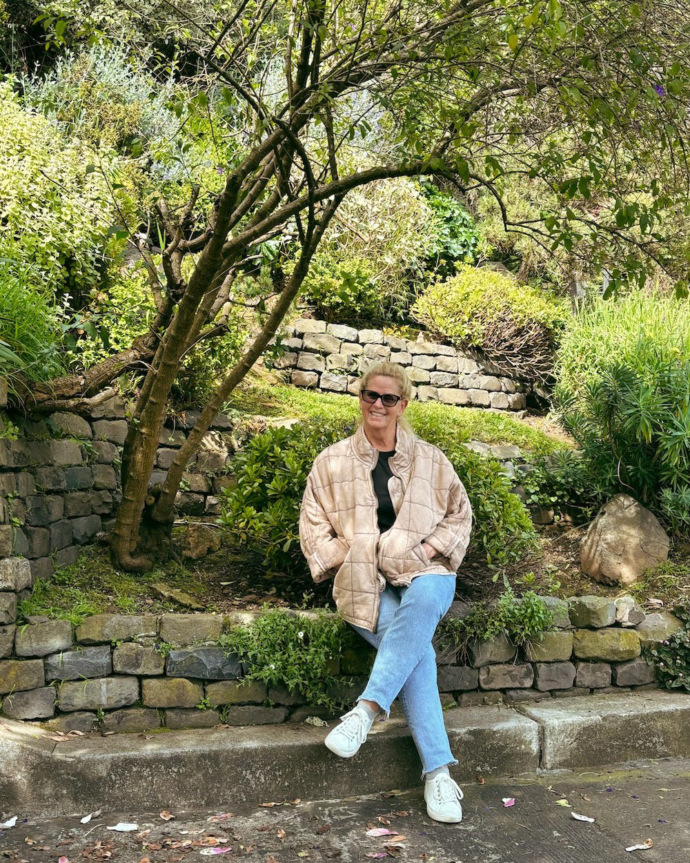 Carrie Green Zinn sitting on the stone walll along the Vulcan Stairway which is one of the hidden steps in San Francisco