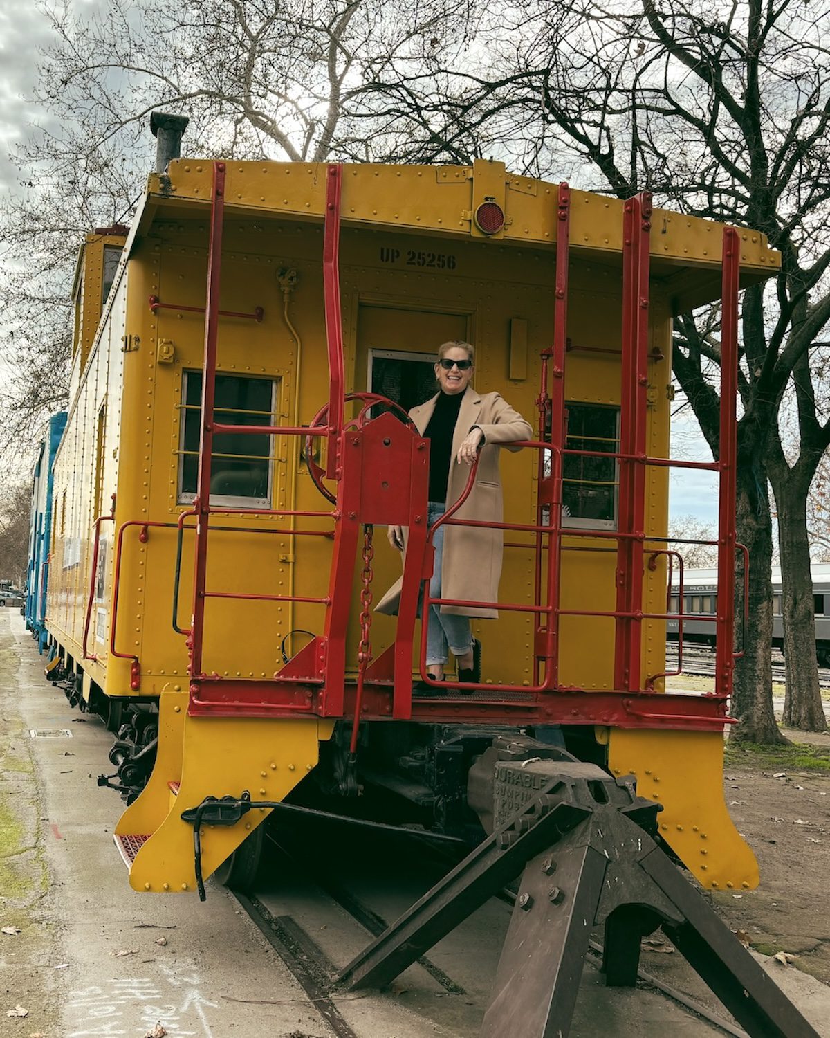 Carrie Green-Zinn standing on a vintage train at the California Train Museum which is one of the things to do that makes Old Sacramento worth visiting.