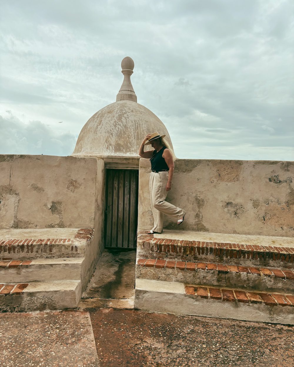 Carrie Green Zinn on the wall of the park overlooking the water in Old San Juan