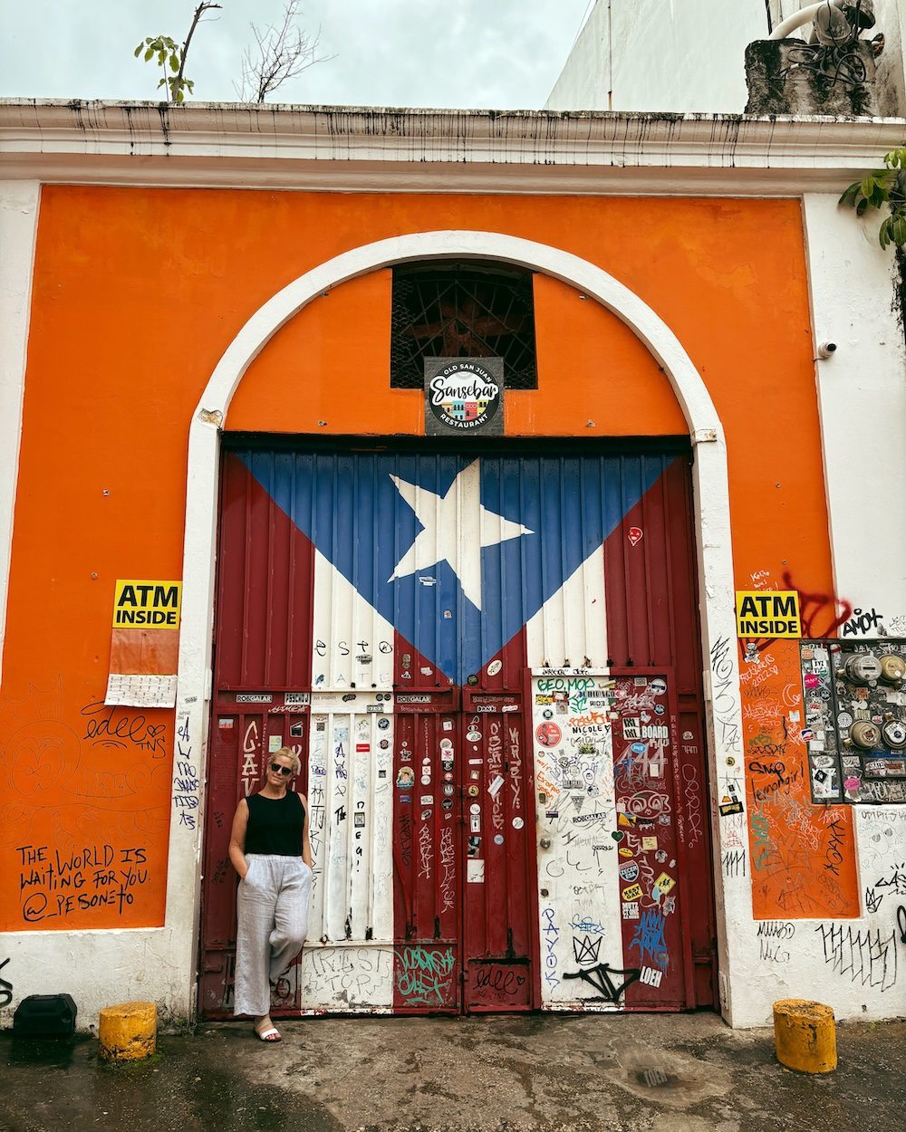 Carrie Green-Zinn in front of the Puerto Rican flag gate in Old San Juan