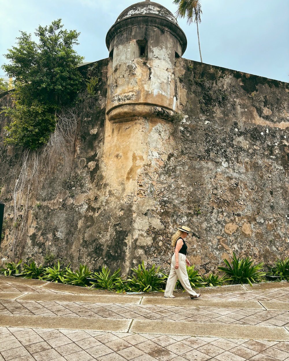 carrie Green-Zinn walking by one of the towers of El Morro which is one of the things to doin Old San Juan.