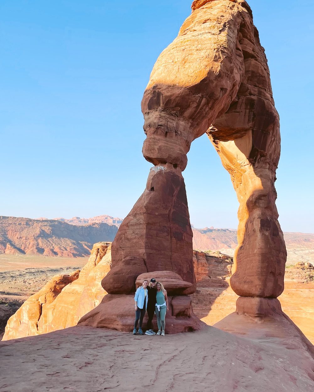 Carrie Green-Zinn and her daughters under the Delicate Arch in Arches National Park in Moab, Utah