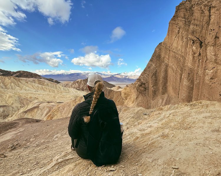 Carrie Green-Zinn sitting on the overlook of Red Rock Cathedral in Death Valley National Park