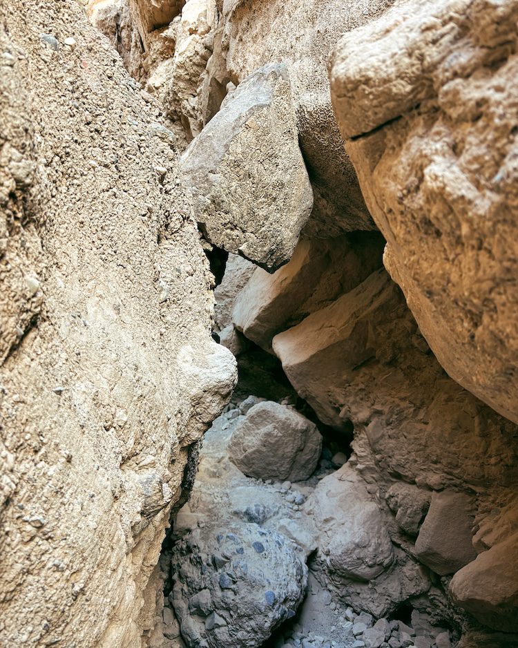 A rock wedged between other rocks on a canyon trail in Death Valley