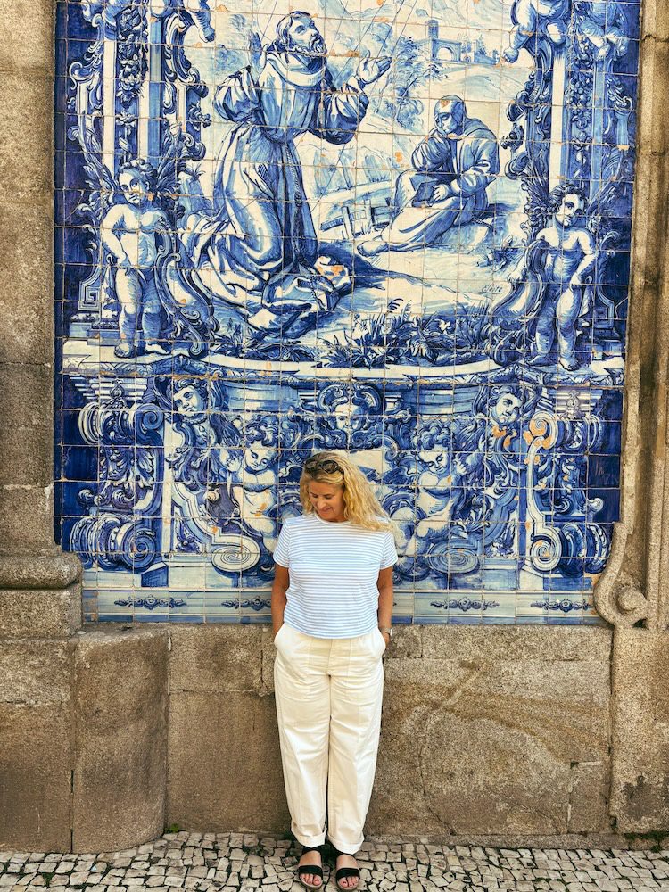 Carrie Green-Zinn in Porto next to a tile wall.